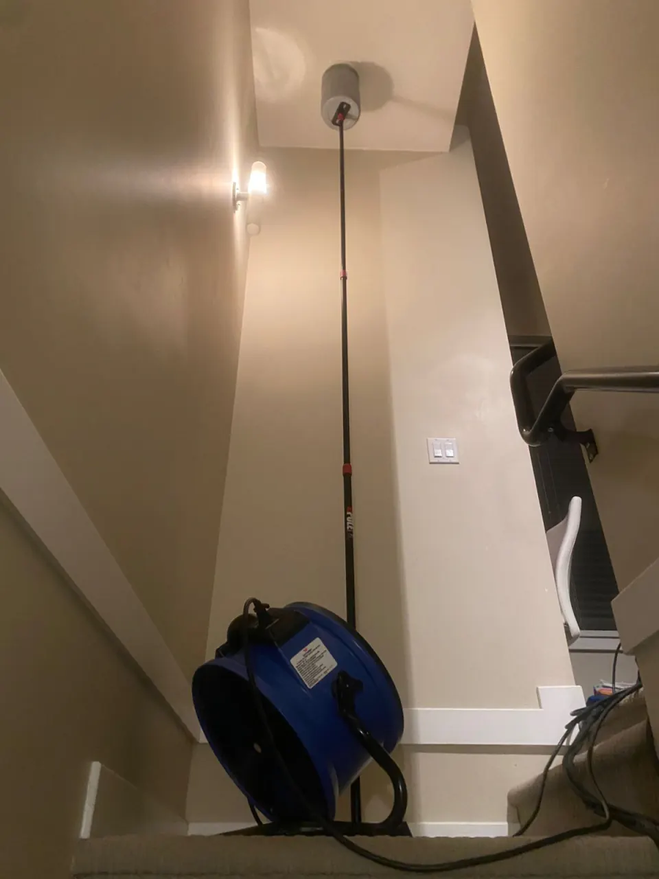High-temperature fan circulating heat in a stairwell, with a fire sprinkler cooling cover on the ceiling