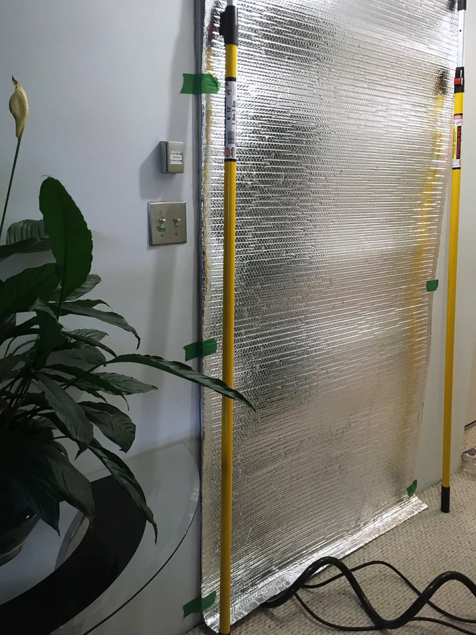 Room sealed with reflective insulation and poles, ready for a bed bug heat treatment